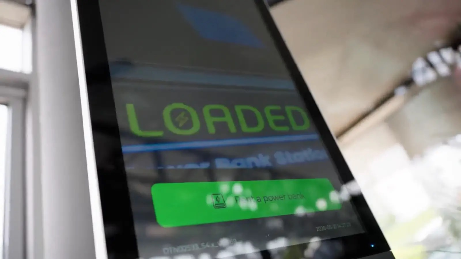 Scherm van een Loaded-powerbankstation met de knop om een powerbank te huren